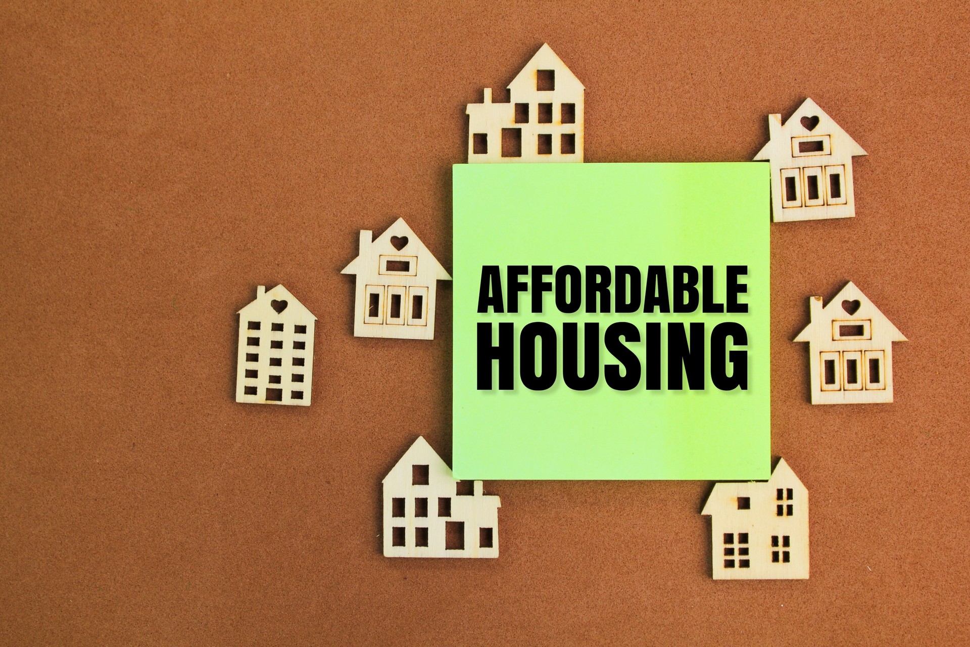 the shape of a wooden house with the word affordable house. affordable housing concept